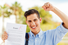 stock-photo-47453356-boy-clenching-fist-while-showing-test-result-with-a-grade